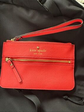 kate spade pinky-red wristlet with gold hardware